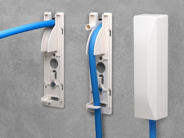 Wall-mounted Filoform cable entry system with three stages shown: open mounting base with blue cable, partially enclosed cable entry, and fully enclosed version with white cover. Installed on a concrete wall for secure and tidy cable routing.